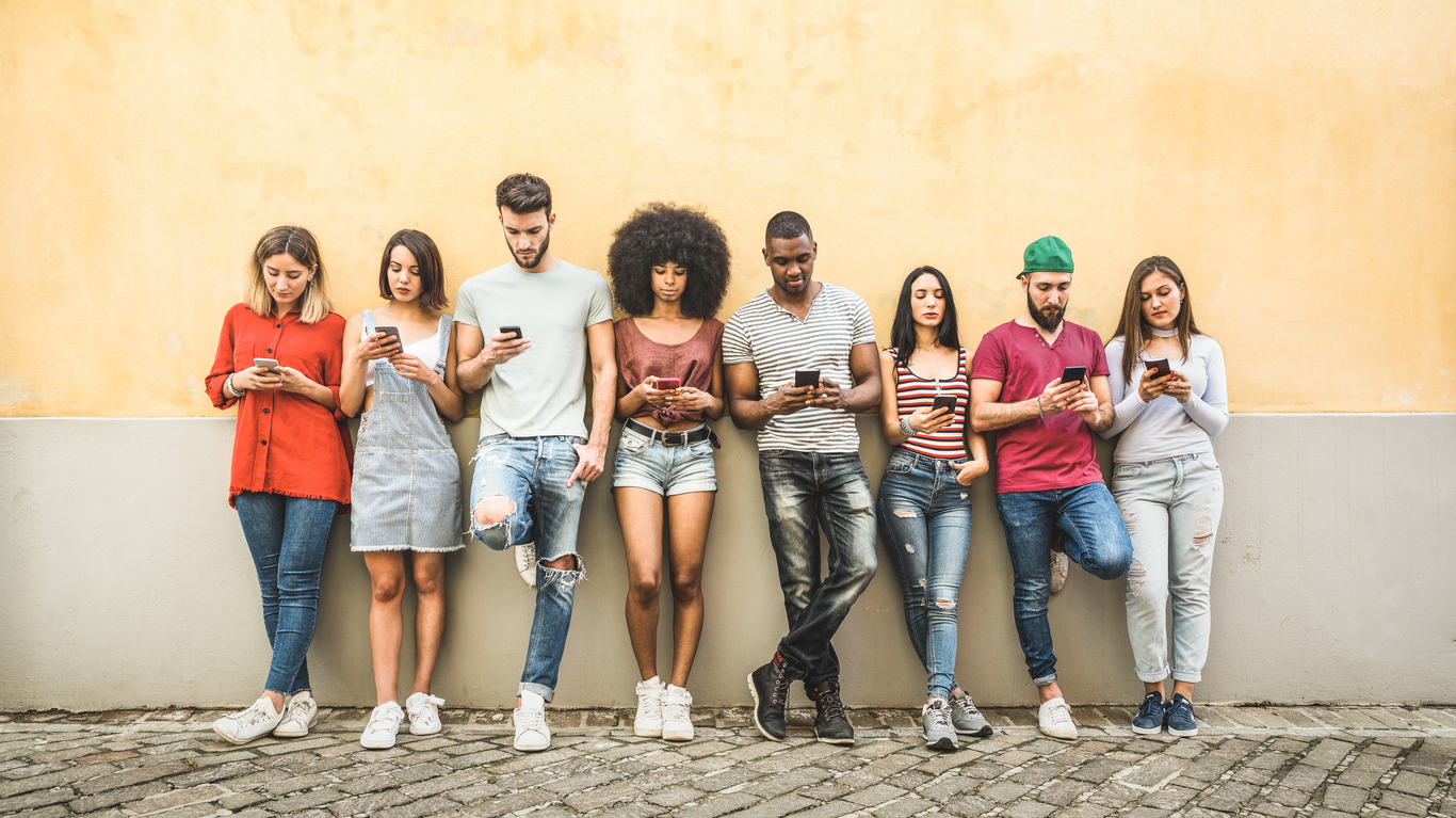 A group of people in their 20s lean against a wall, all using their smartphones. Web Impact Marketing and The Valley List have partnered together to offer digital marketing solutions for companies everywhere.