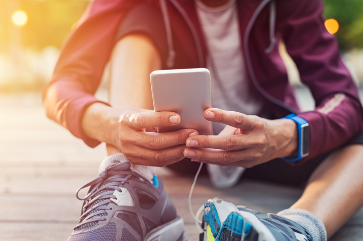 A young person sits on the ground with their cellphone. The Valley List is here to provide app development in Olmos Park, Texas.