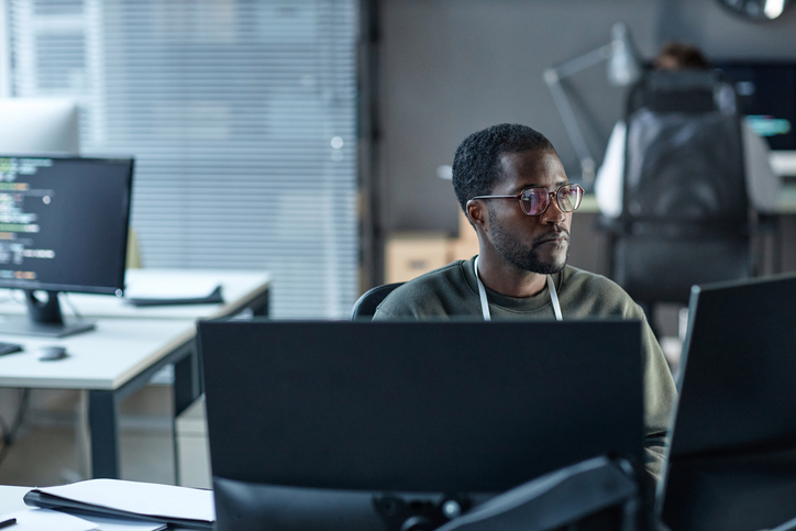 A man works at his computer in an office setting, developing a website. The Valley List is a trusted custom web developer in Dublin, Ohio.