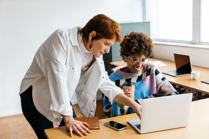Two women working together at a computer. The Valley List offers custom web development across the US.