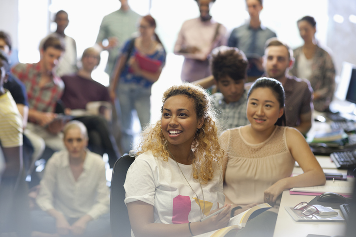 A group of folks sit at a desk, all listening to someone who is not in the photo. The Valley List prioritizes digital accessibility in both their mobile apps and website design