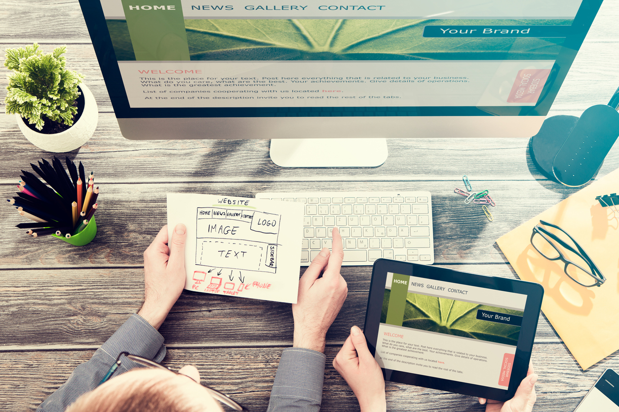 A designer works at a computer to provide a website optimized for SEO.