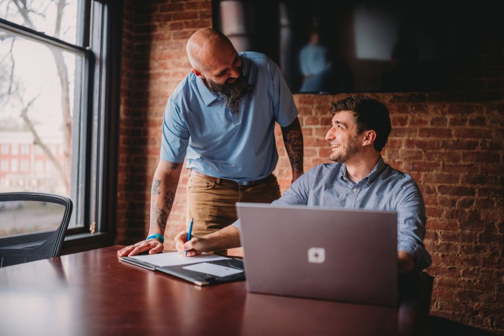 Chris and Josiah collaborating on laptop for white label support for agencies Nationwide.