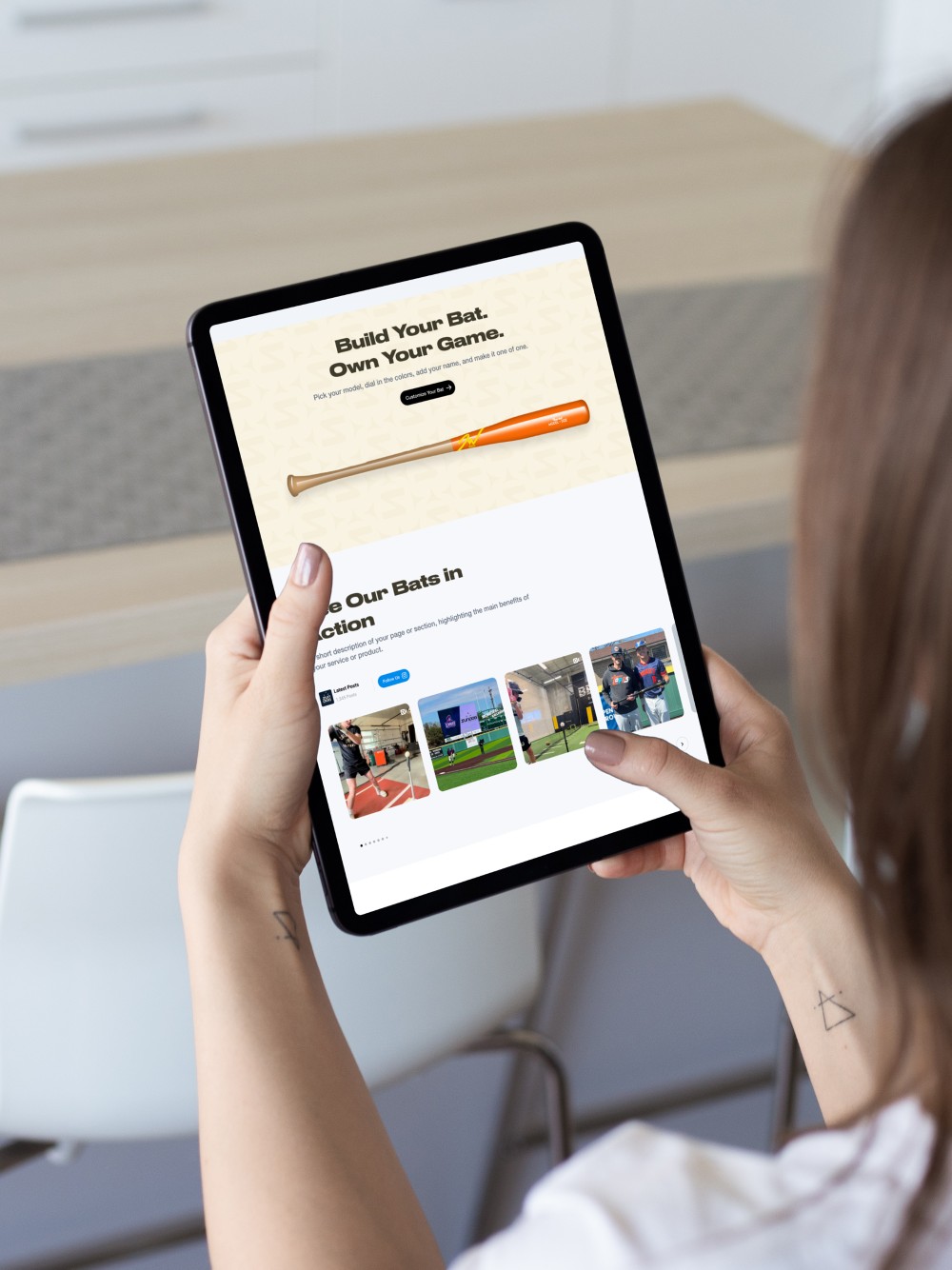 A person is on the Sundog Bats website using a tablet.